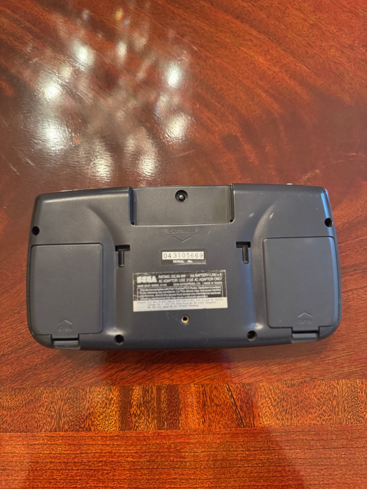 Back of the Sega Game Gear showing cartridge slot, serial number, and battery compartments