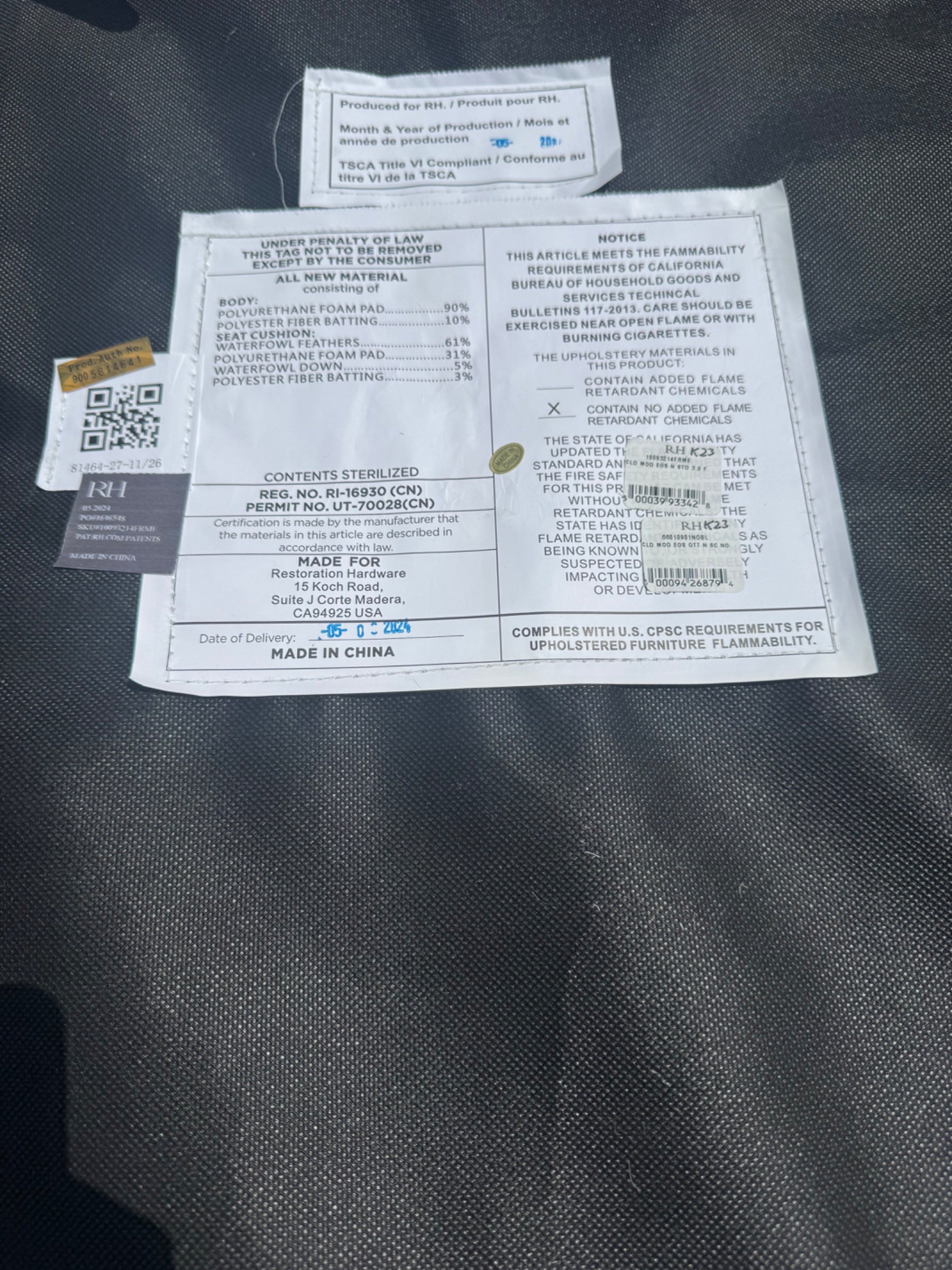 Close-up of care label and compliance documentation attached to gray Sunbrella cushion fabric
