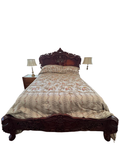 Carved rococo bed seen from the foot in a bedroom