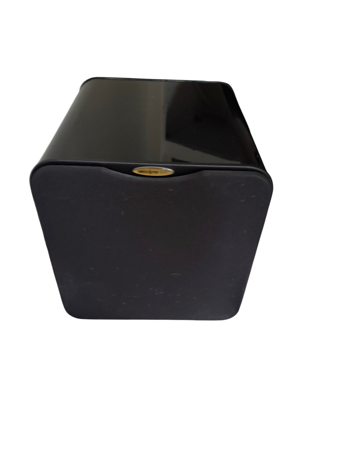 Black high-gloss Velodyne powered subwoofer with cloth grille on a wood floor near a media shelf