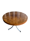 Burl wood round tabletop with figured grain pattern, polished finish, viewed from above at angle