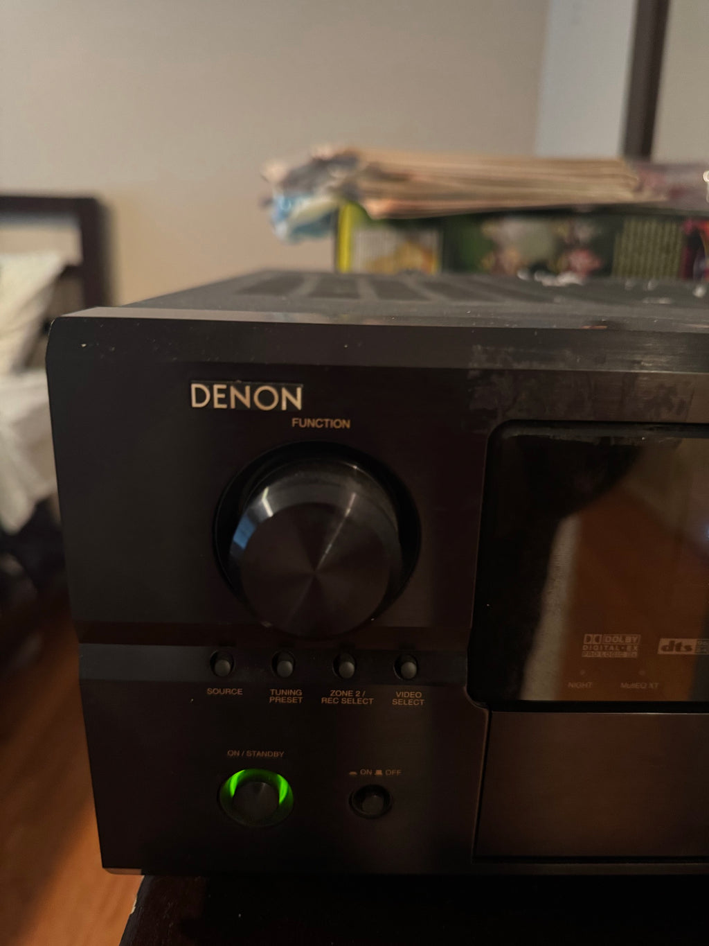 Angled close-up of Denon AVR-2807 faceplate with power button lit green