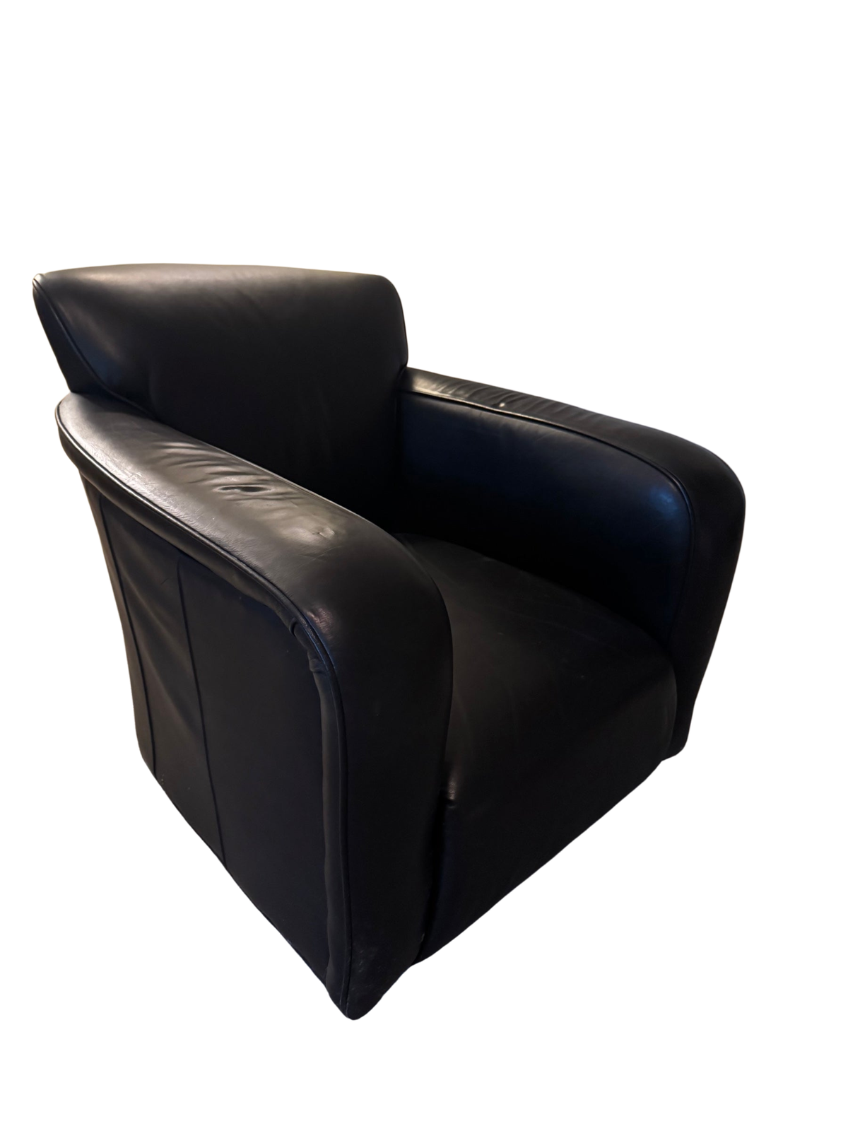 Black leather barrel chair viewed from the side showing rounded back and arm