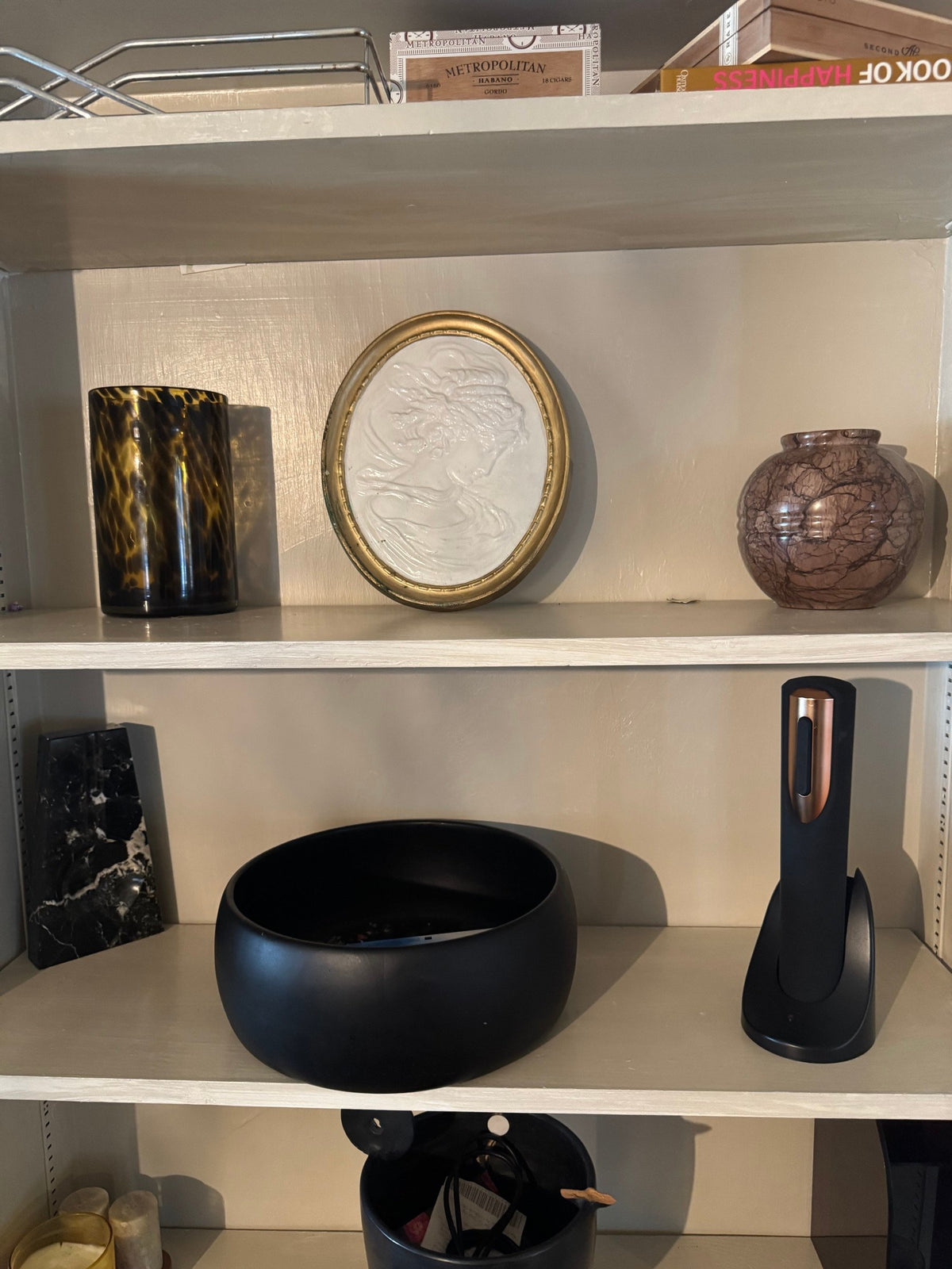 Close view of the glass vase, cameo plaque and black bowl