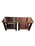 Pair of mahogany two-tier side tables with brass trim and casters, viewed from front