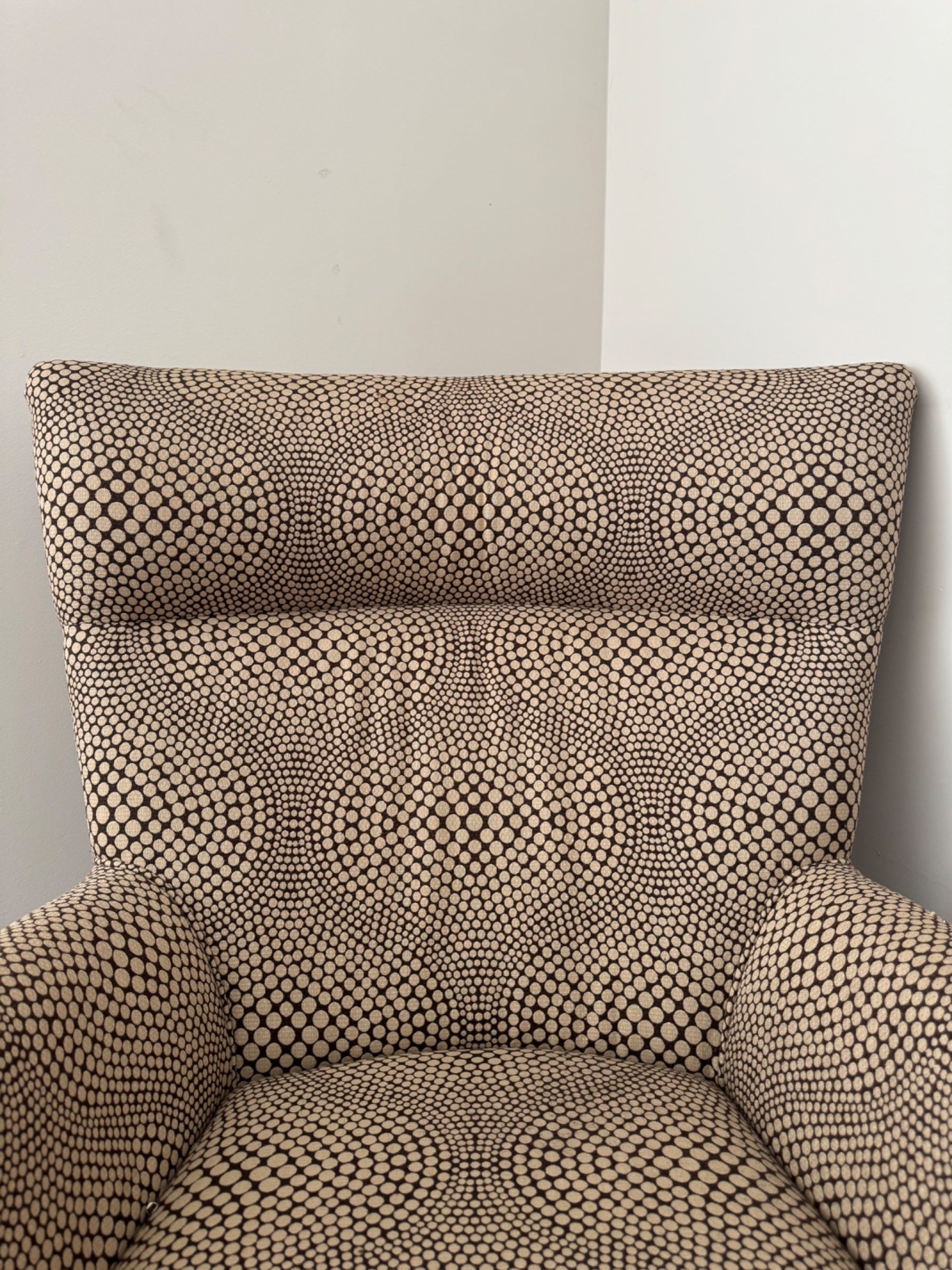 Close-up of arm detail and seat junction showing fabric pattern and upholstery construction