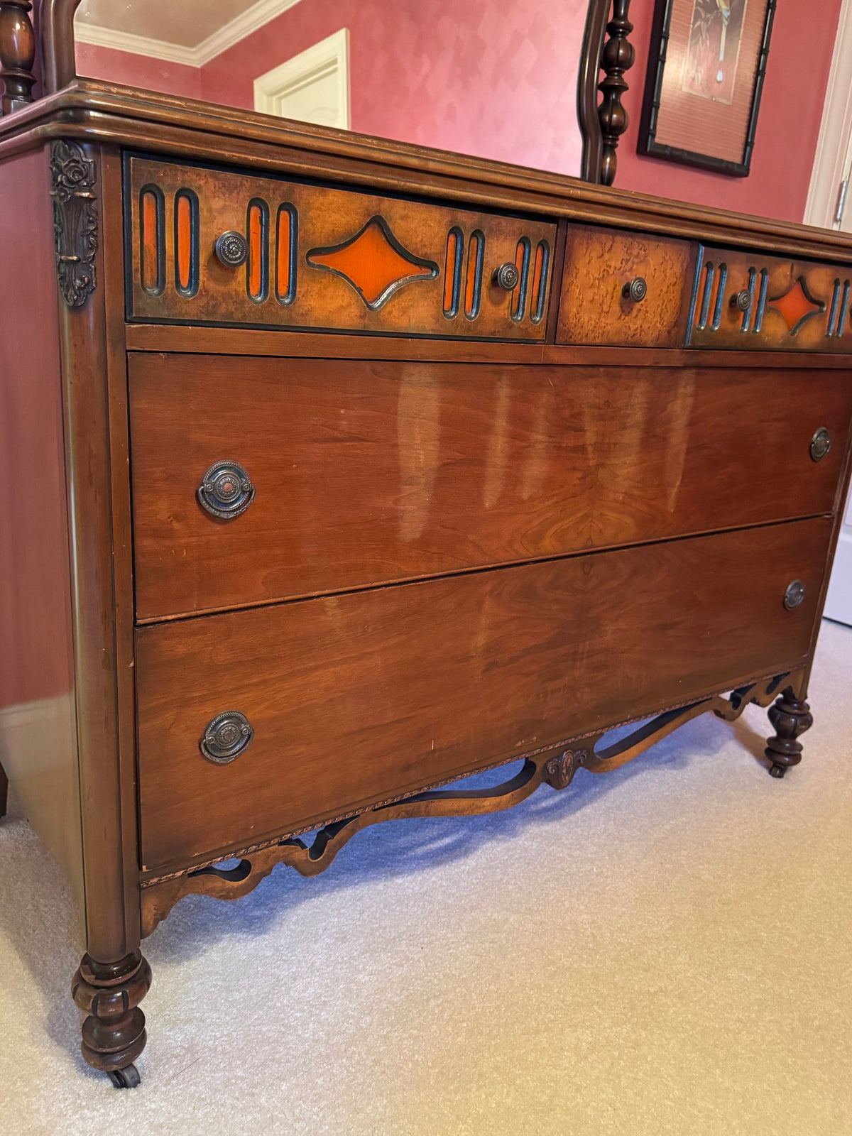 Close-up of drawer detail showing walnut veneer, orange/rust geometric star inlays, vertical line patterns, and metal ring pulls