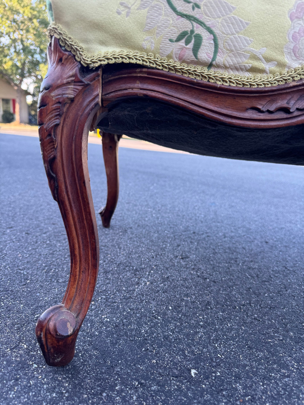 The front leg from below, showing the carved knee, the moulded serpentine seat rail and the scrolled toe