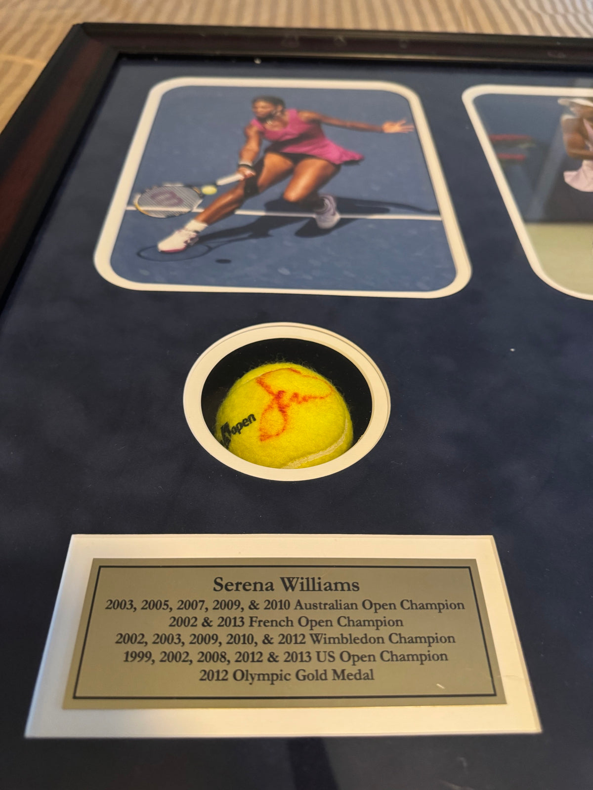 Close-up of Serena Williams photo and signed tennis ball with nameplate listing her titles