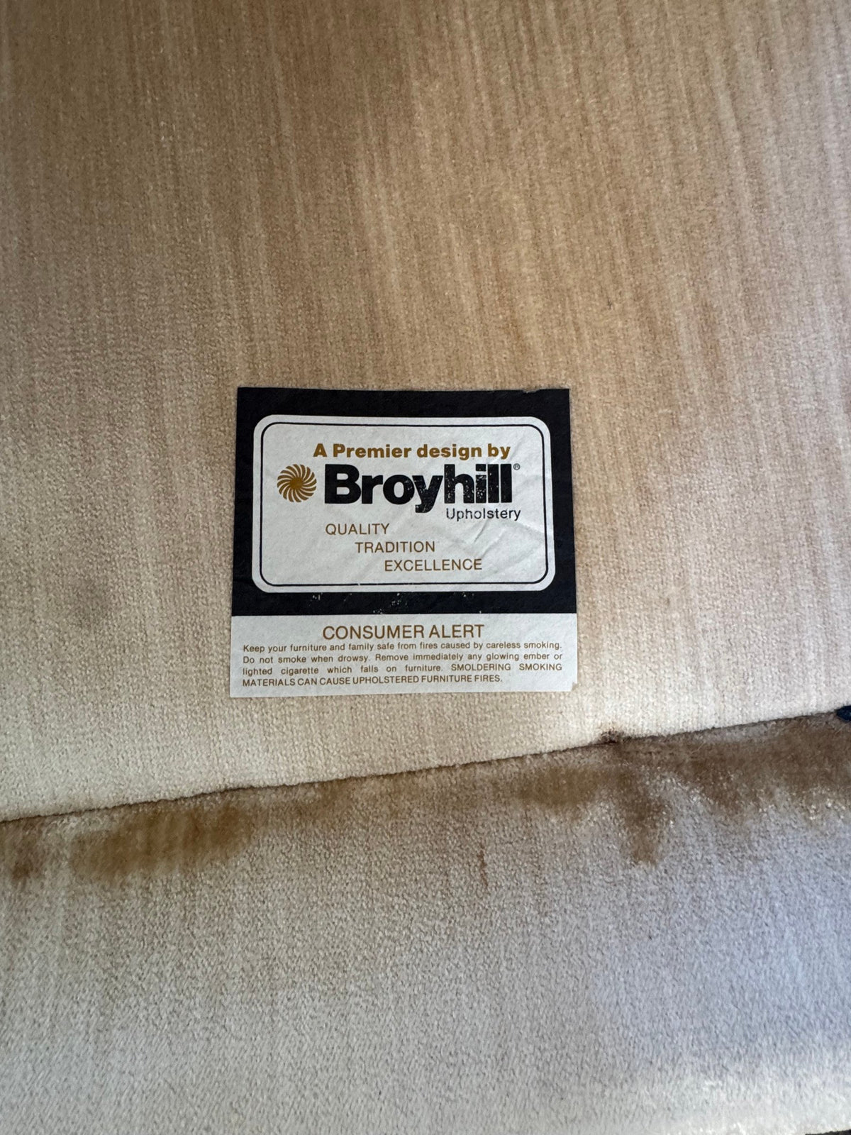Broyhill label on the underside with staining on the fabric below it
