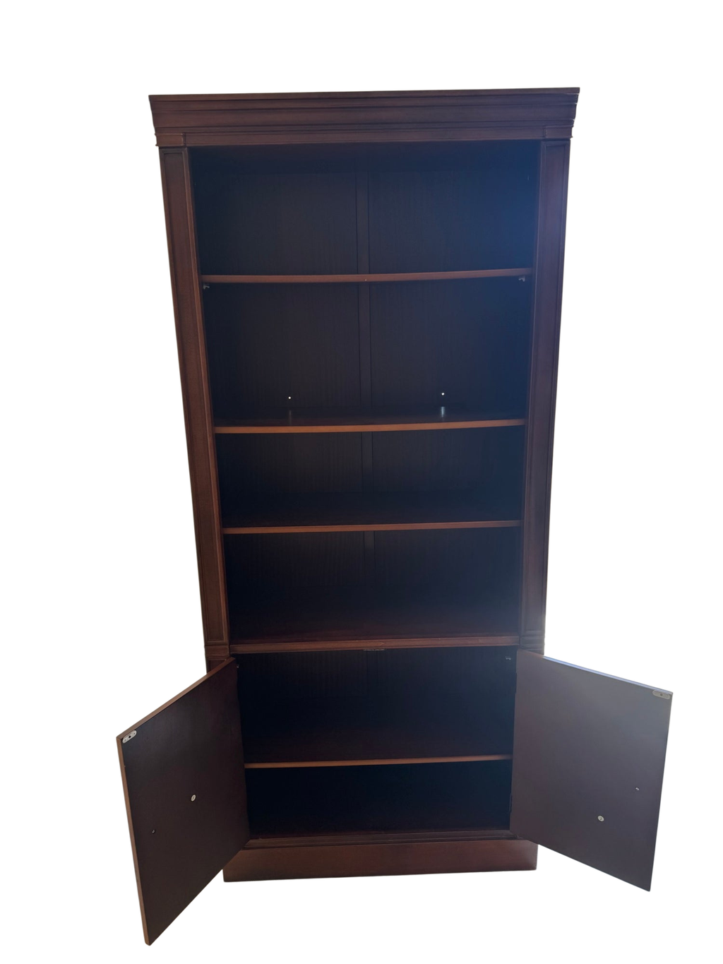 Tall mahogany bookcase with open shelving upper section and closed cabinet base with oval inlaid panels, front view