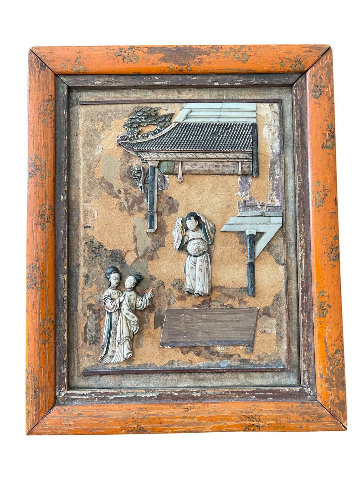 Framed carved wooden panel with pagoda roof, figures, and architectural details in relief, orange wood frame with patina