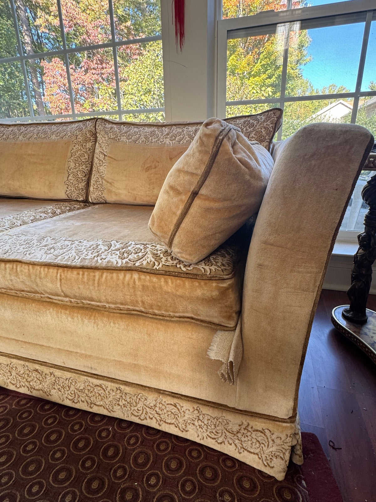 Sofa arm and skirt detail showing the scrolling border trim
