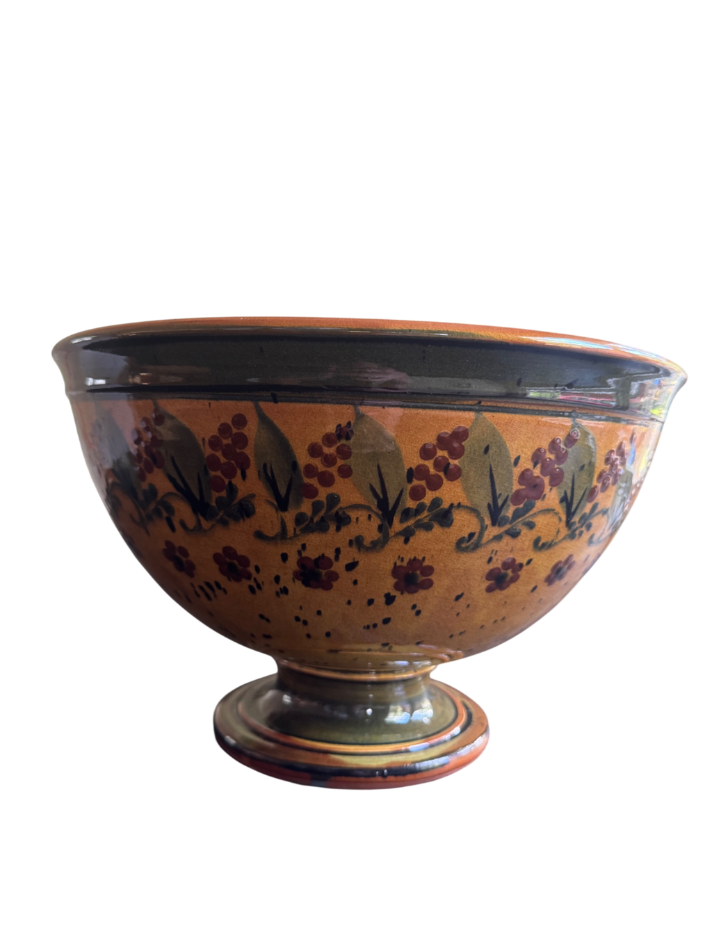 Footed ceramic bowl with terracotta glaze, decorated with dark burgundy floral motifs and leafy sprigs around upper body