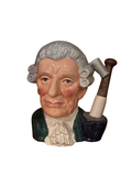 Front view of Royal Doulton-style character jug featuring Georgian gentleman with gray curled wig, holding pipe-handled axe