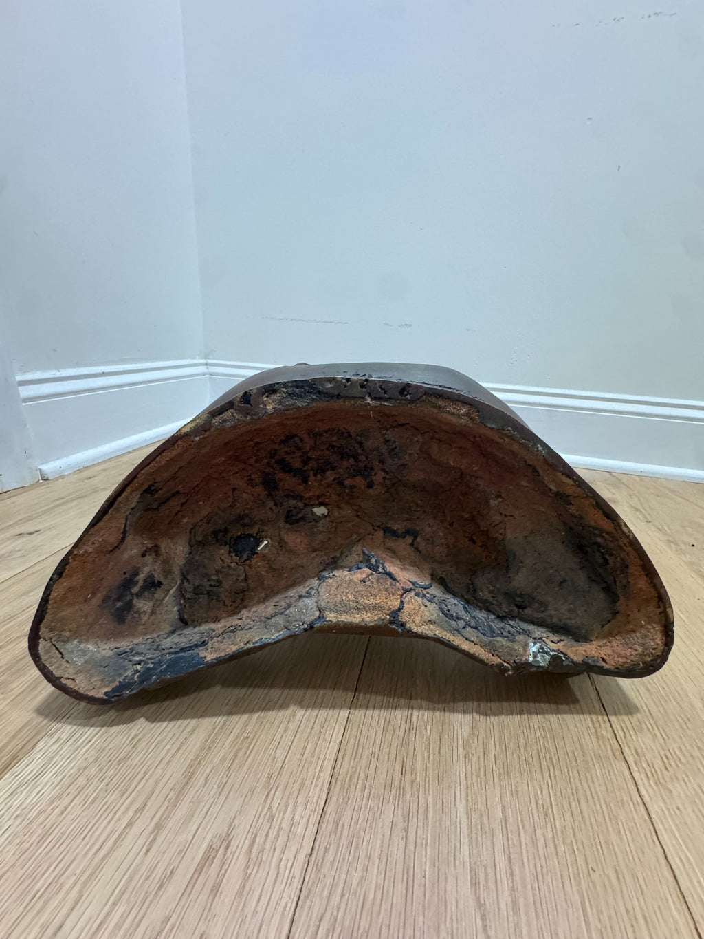 Underside view of Buddha base showing hollow cast interior with patina and wear marks