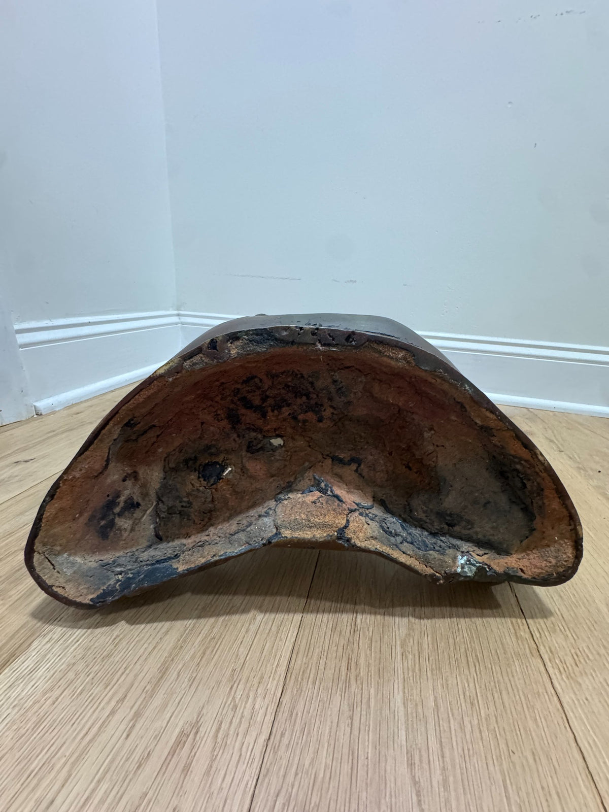 Underside view of Buddha base showing hollow cast interior with patina and wear marks
