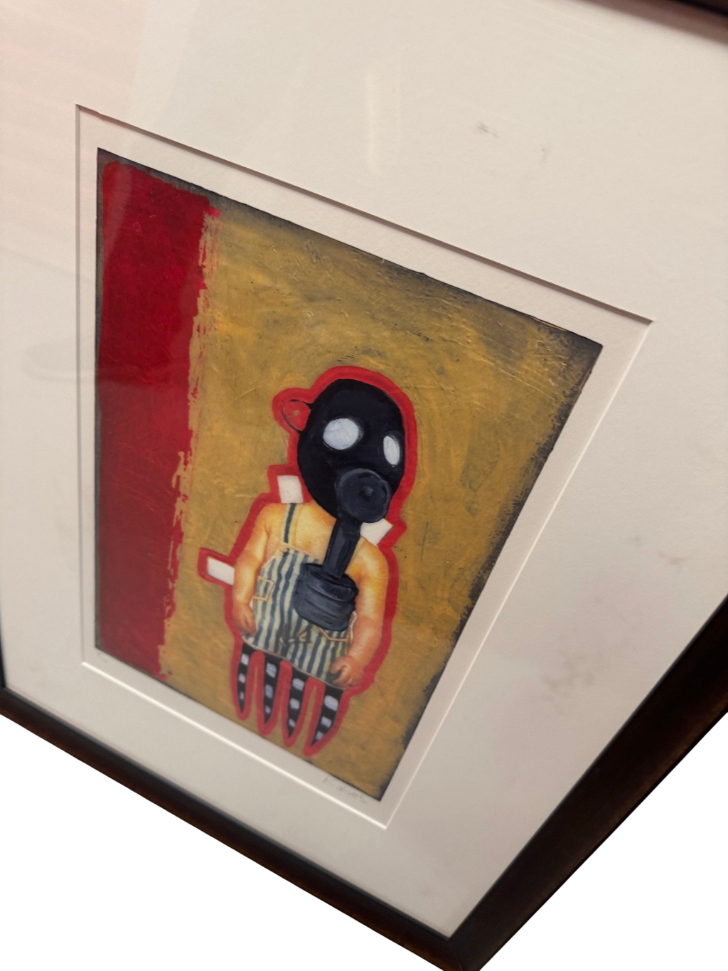 Framed gas-mask figure on a red and mustard ground in a dark wood frame with cream mat