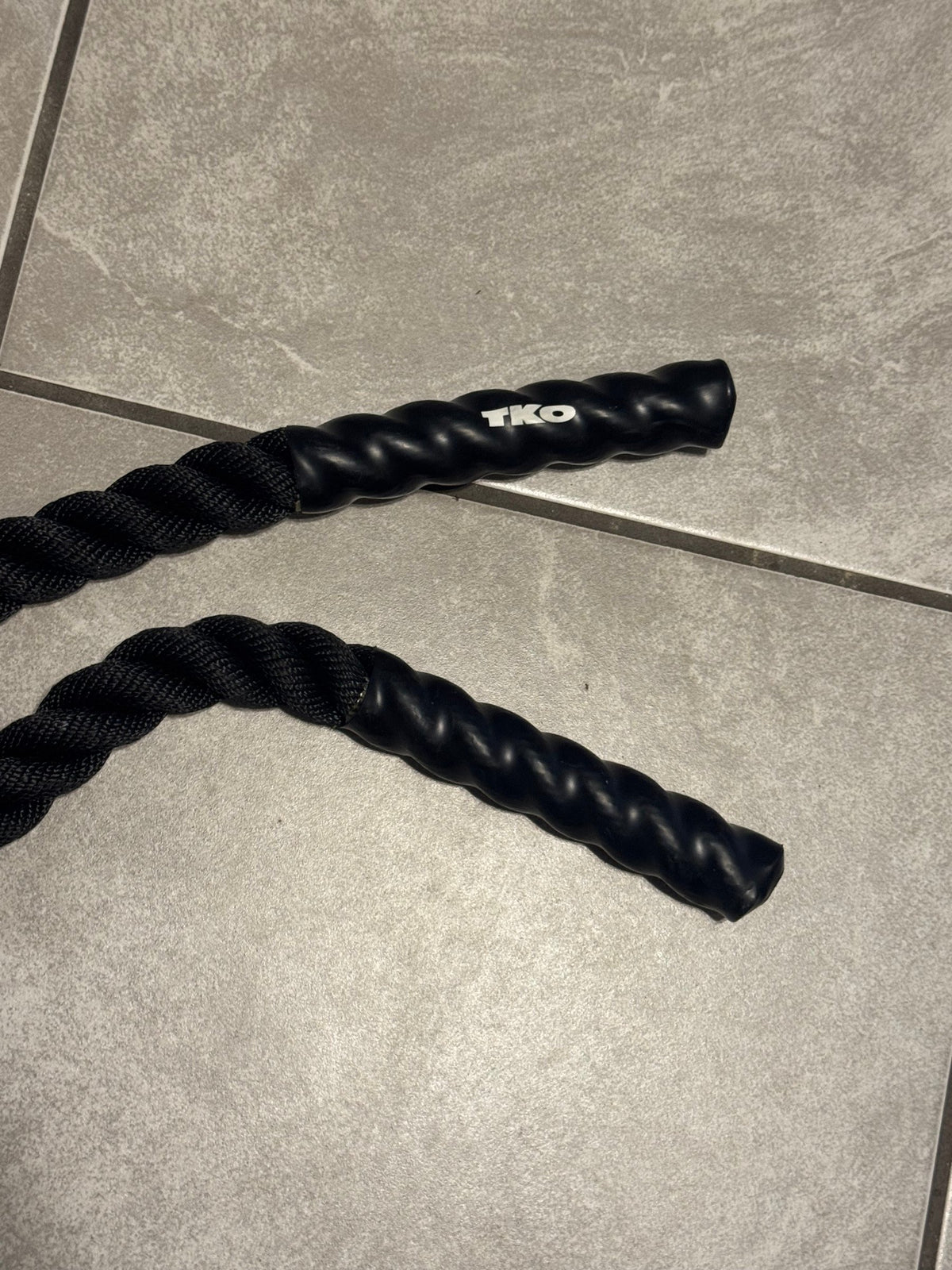 TKO battle rope end on a tile floor