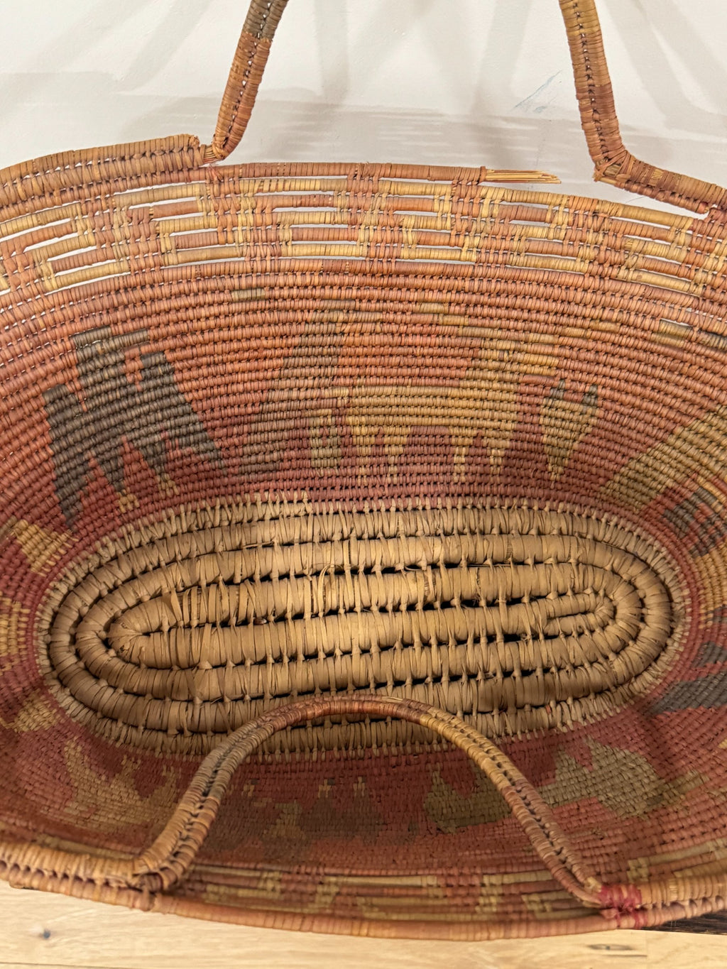 Top-down interior view revealing oval base weaving pattern and radiating coiled construction technique