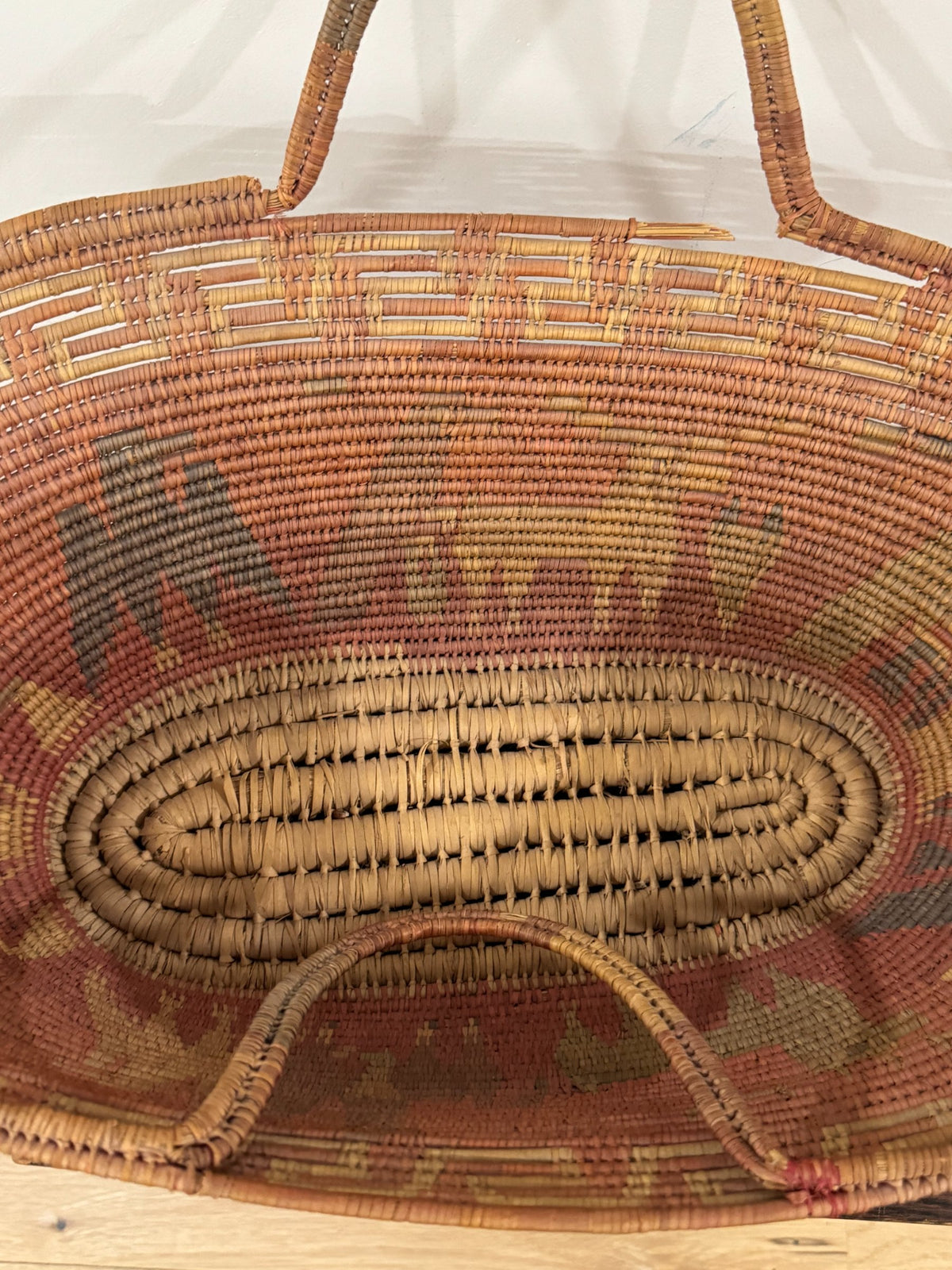 Top-down interior view revealing oval base weaving pattern and radiating coiled construction technique