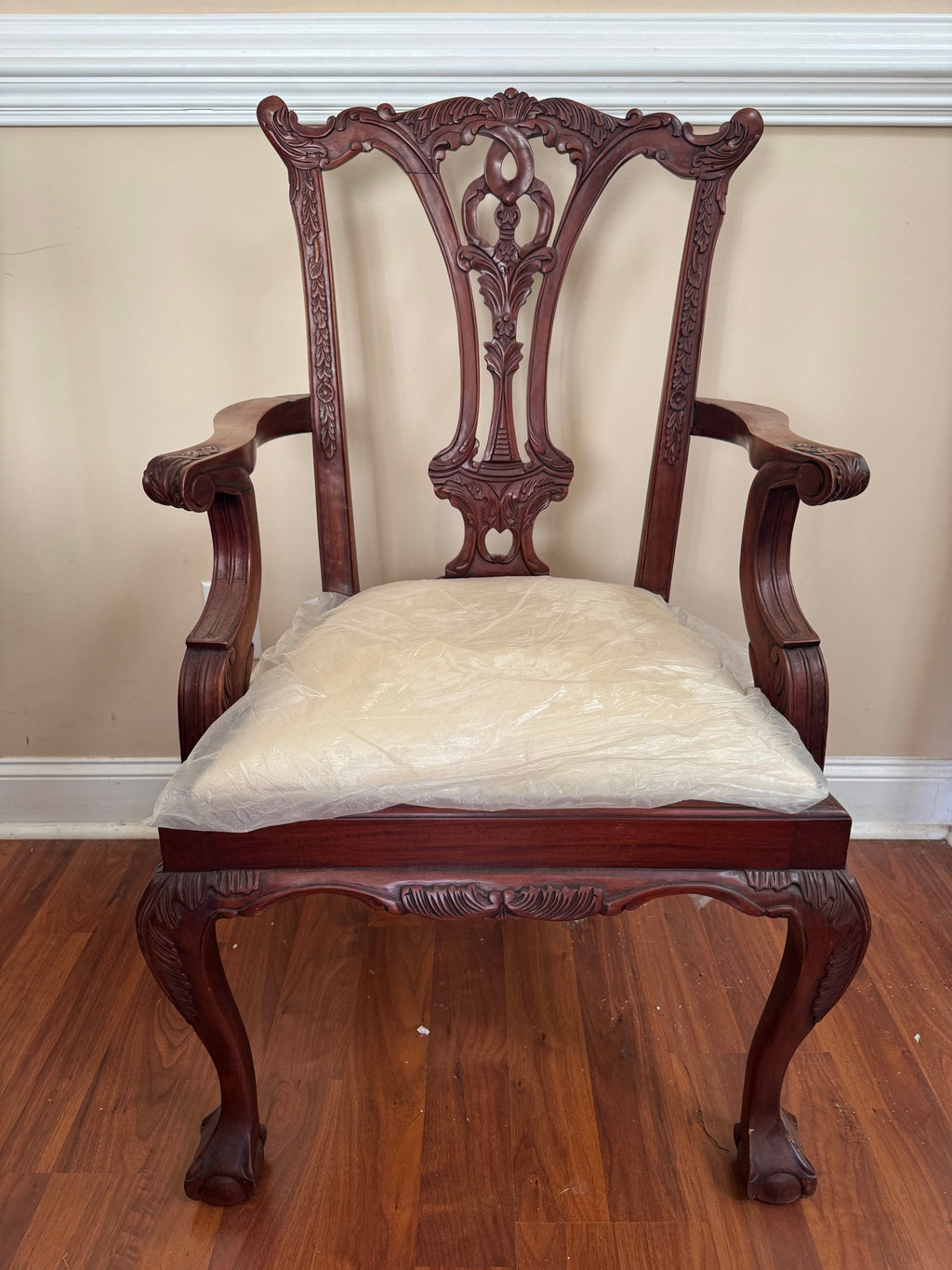 Carved armchair with pierced splat back and ball-and-claw feet, seen from the front