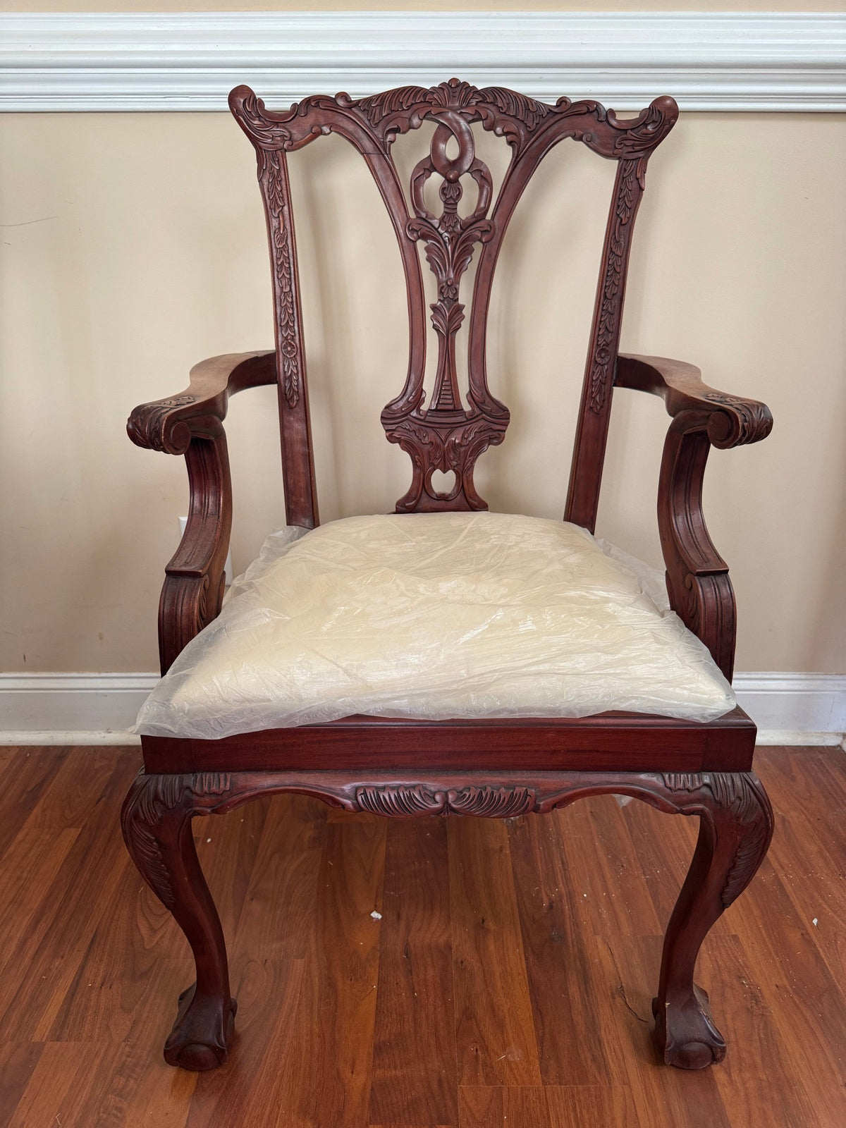 Carved armchair with pierced splat back and ball-and-claw feet, seen from the front