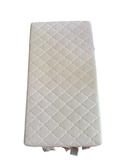 White quilted crib mattress with diamond quilting pattern, viewed from above at an angle
