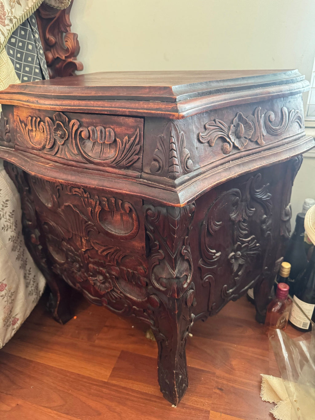 Nightstand from an angle showing carved drawer and curved legs