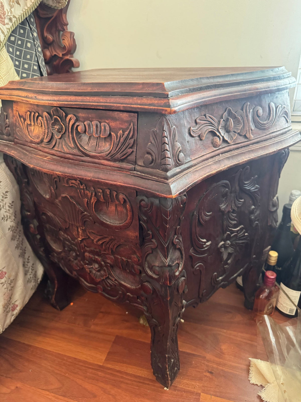 Nightstand from an angle showing carved drawer and curved legs