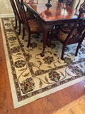 Ivory floral Oriental style rug under a dining table and chairs