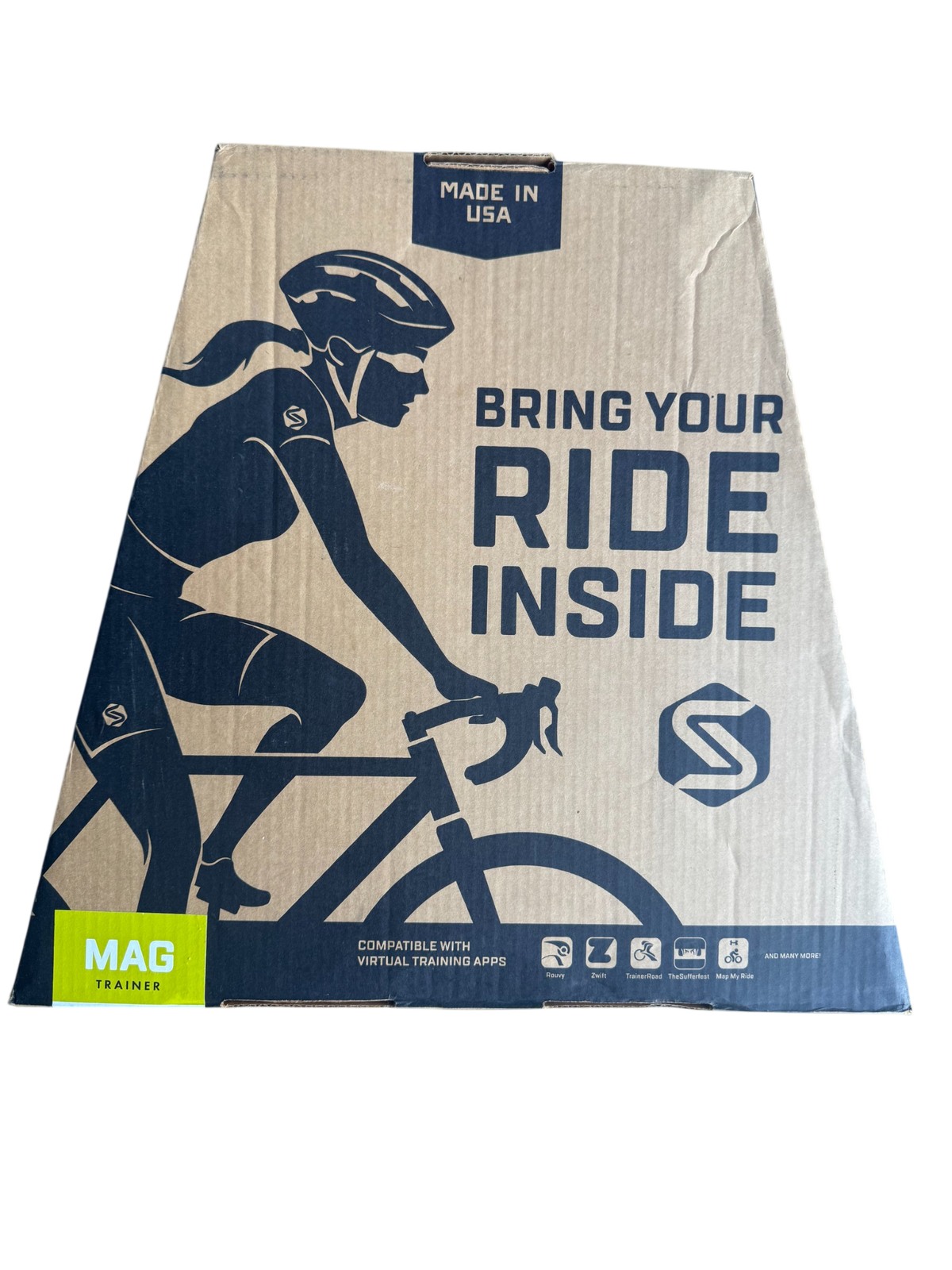 Cardboard shipping box front featuring cyclist illustration, navy and cream design, 'Bring Your Ride Inside' text, made in USA