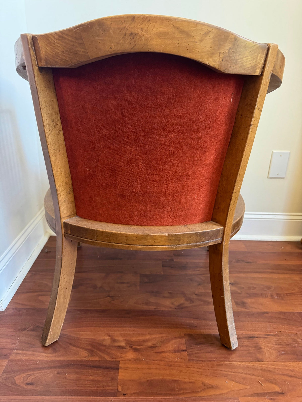 Back of the barrel chair with rust velvet panel and curved top rail