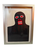 Black figure with red teeth print in silver frame, straight-on