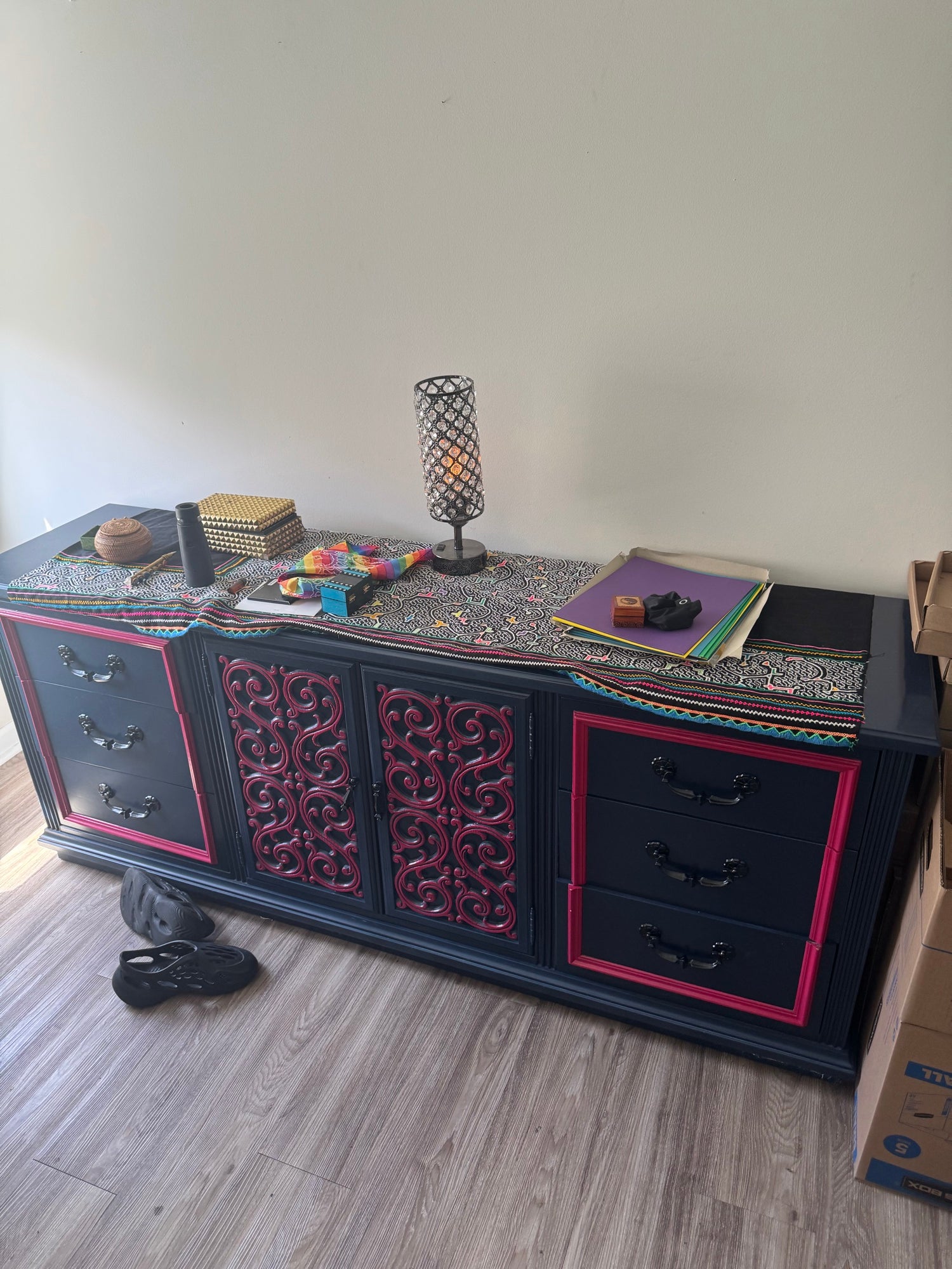 Same credenza in natural lighting indoors, showing full length with decorative items arranged on top surface