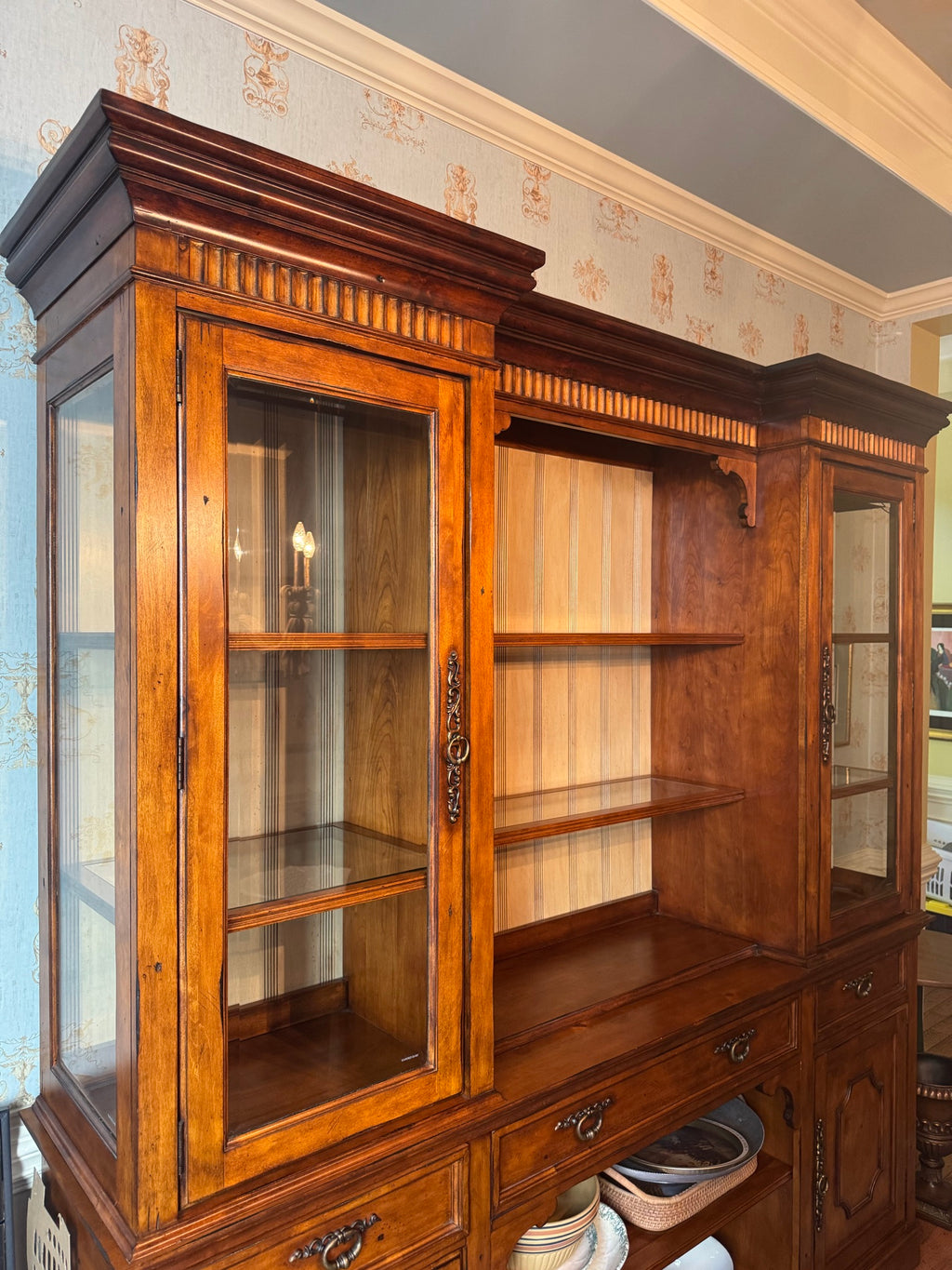 Left side angled view displaying glazed glass doors on left, open shelving center with wood backing, right glass cabinet, lower storage