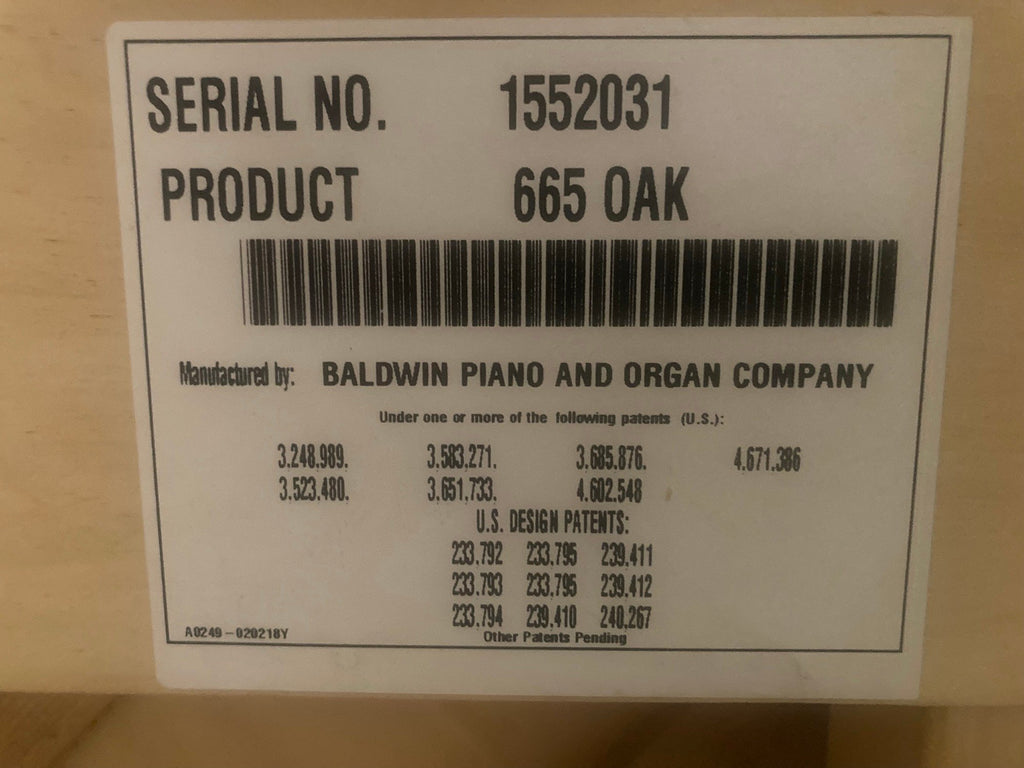 Baldwin factory label on the back of the piano reading Product 665 Oak, serial 1552031