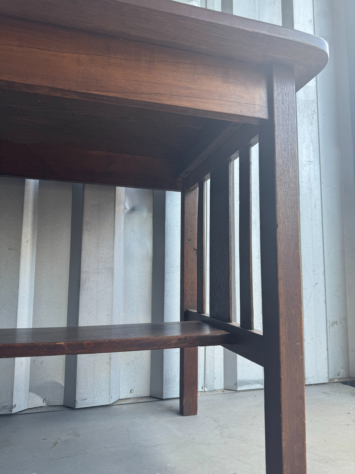 Close-up of table's underside and interior shelf, showing wood grain and shelf support structure