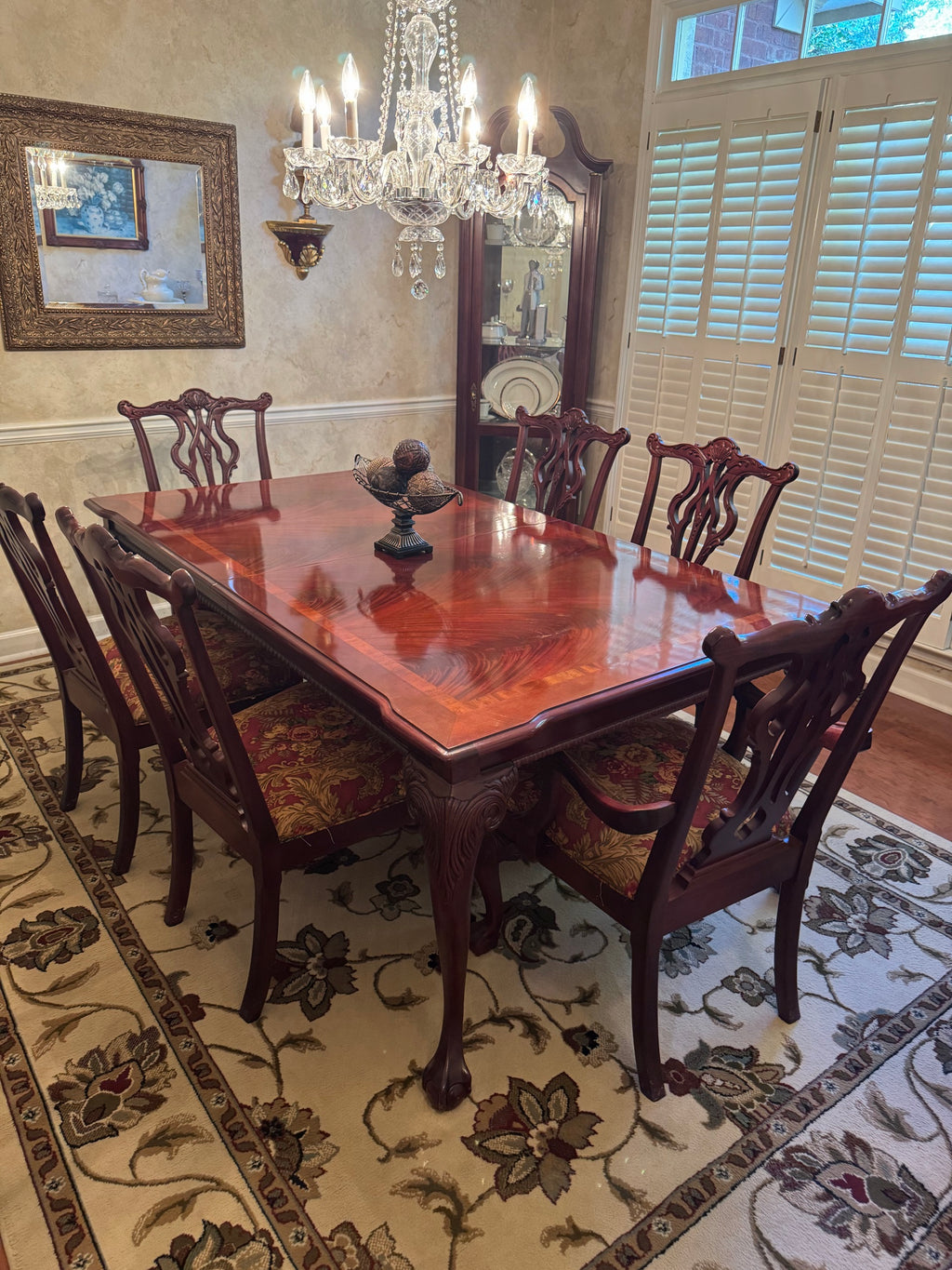 Dining room with mahogany table, crystal chandelier, and eight Chippendale-style chairs