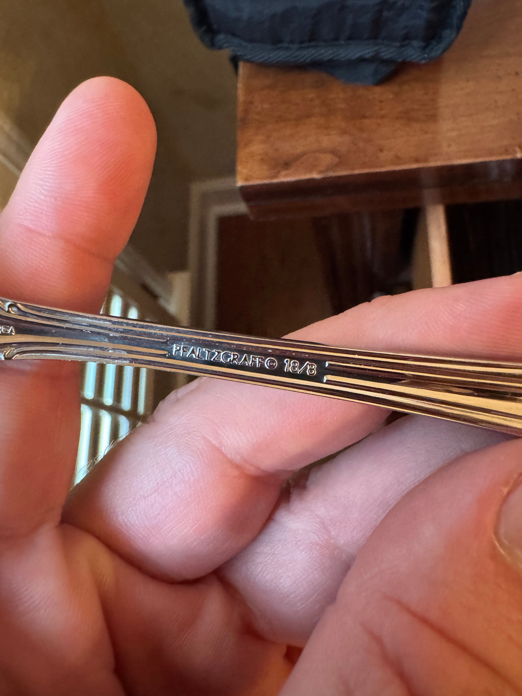 Close-up of engraved Pfaltzgraff 18/8 marking on the back of a flatware handle
