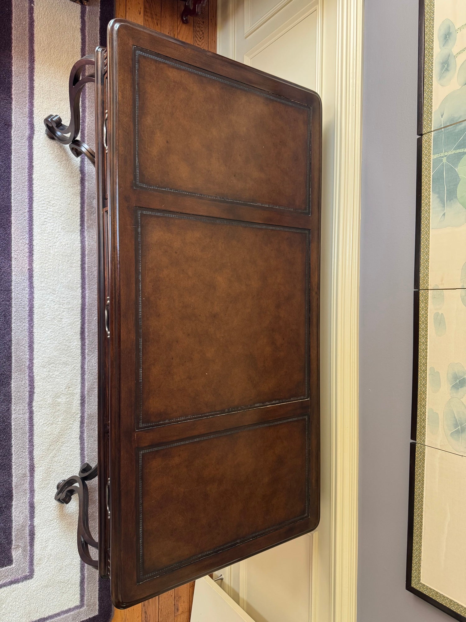 Leather top panel showing tooled border detail and rich brown patina with metal hardware visible