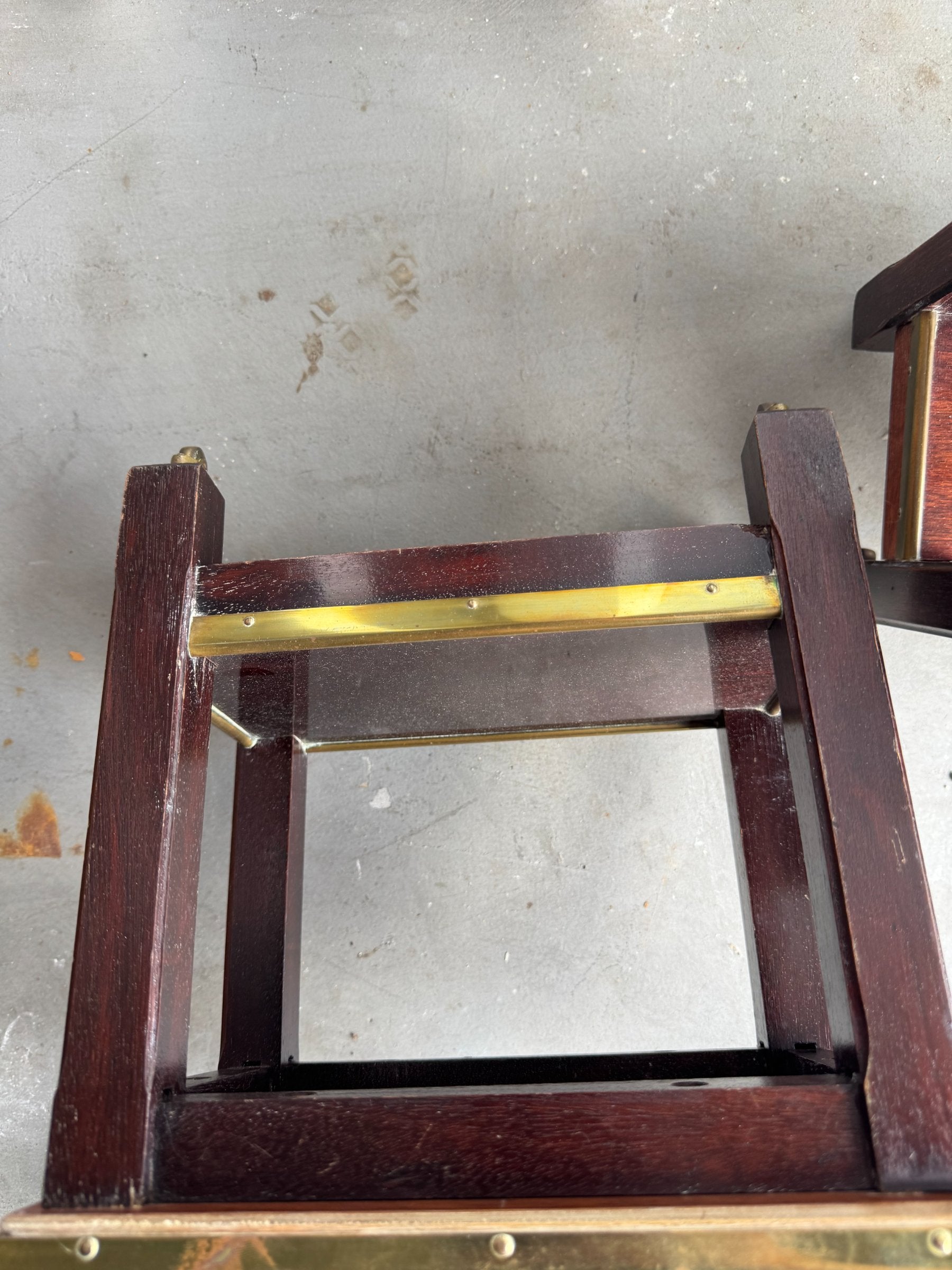 Interior view of one table showing wooden shelf supports and brass rail hardware