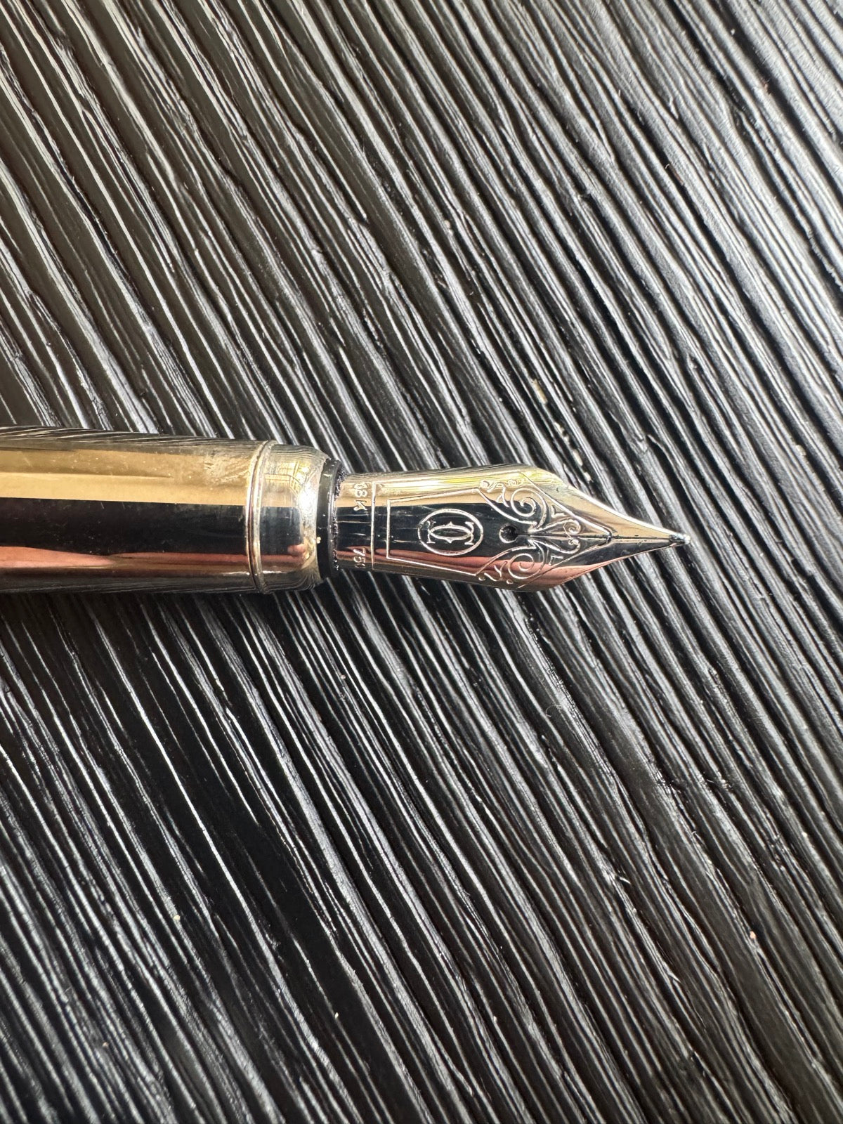 Close-up of fountain pen nib showing decorative gold inlay work and split nib detail