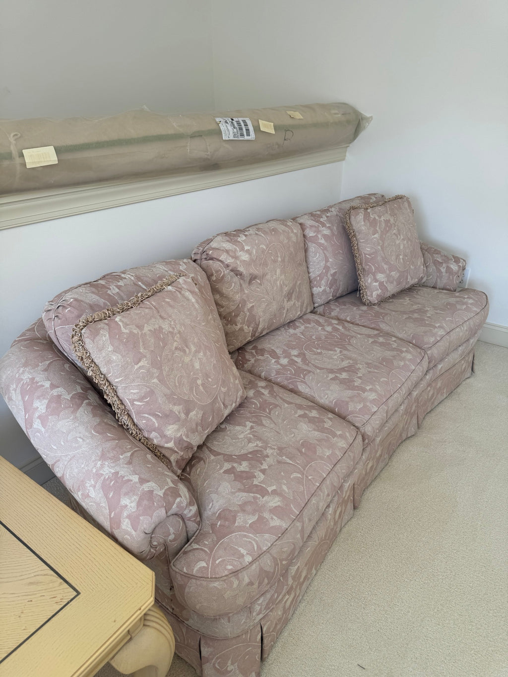 Mauve floral damask sofa angled side view showing rolled arm detail and cushion construction