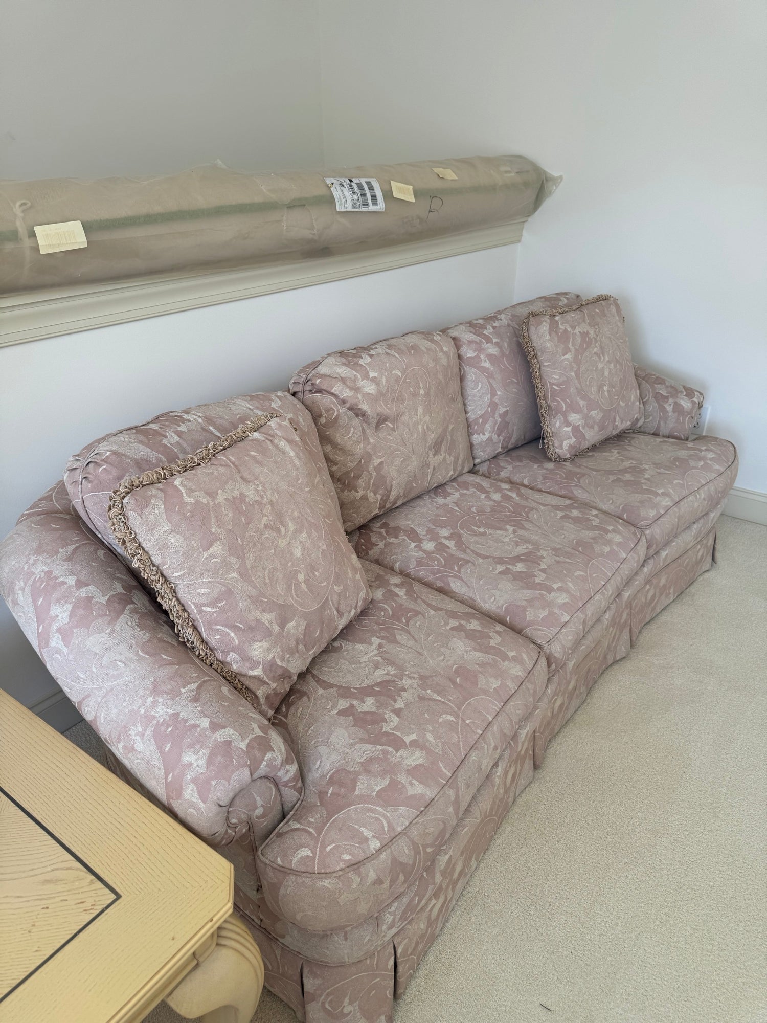 Mauve floral damask sofa angled side view showing rolled arm detail and cushion construction