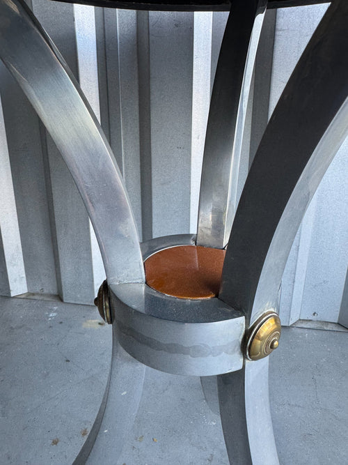 Chrome curved base legs with metal band clamp and brass cap feet, underside view of table structure