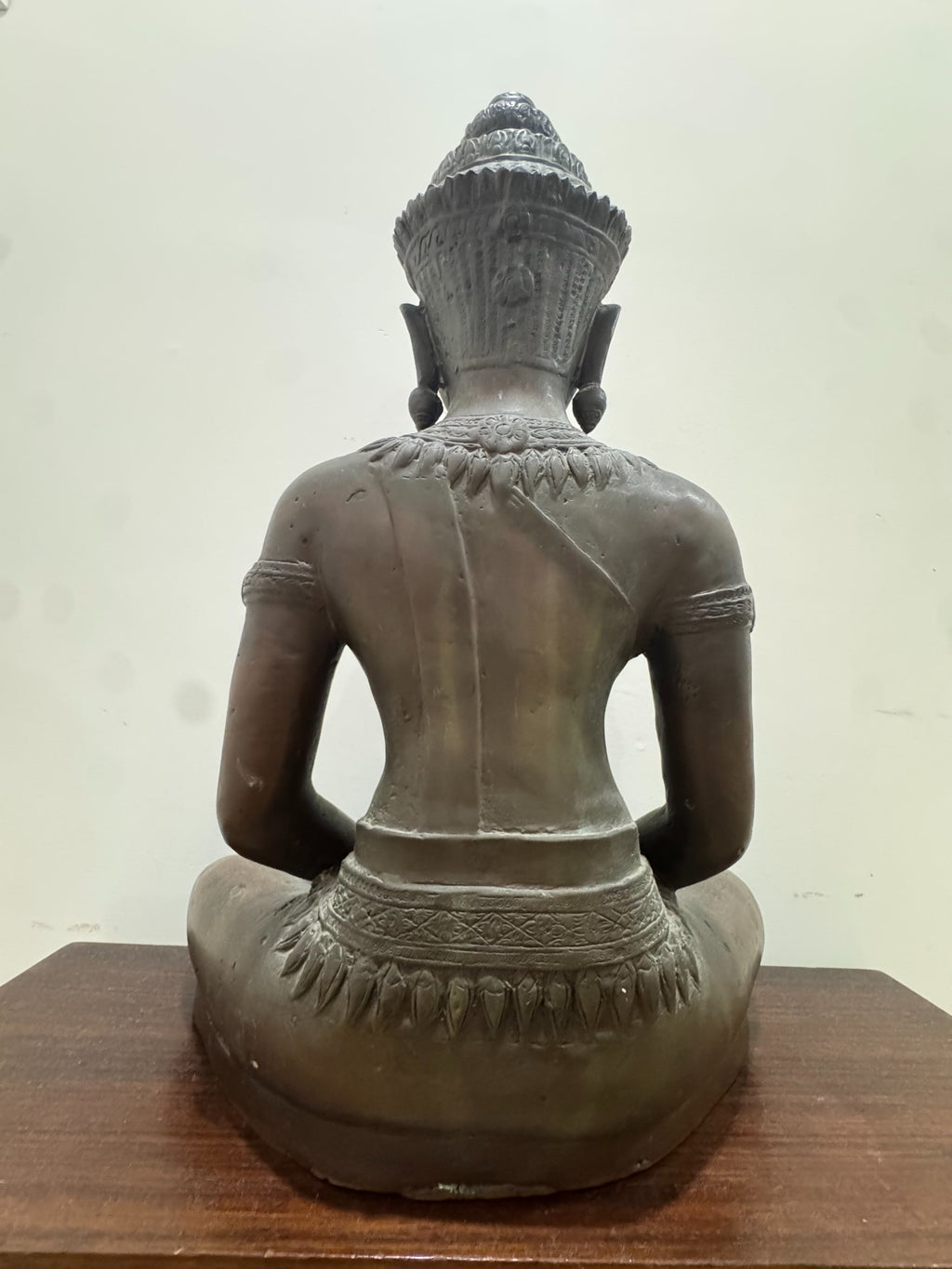 Back view of Buddha figure seated in lotus position, showing rear torso details and crown from behind