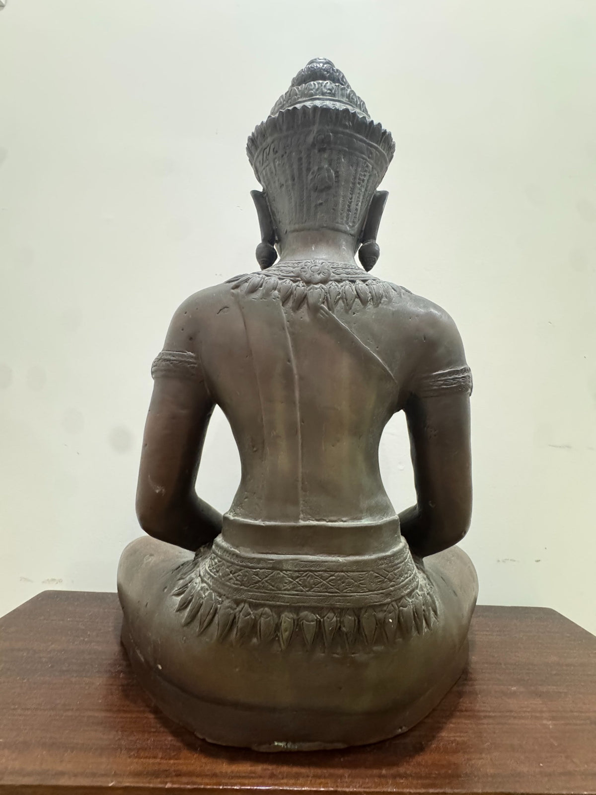 Back view of Buddha figure seated in lotus position, showing rear torso details and crown from behind