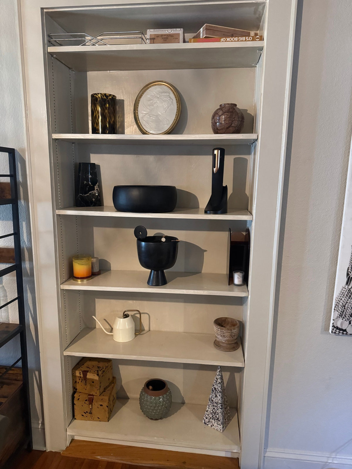 Shelf of assorted decor in black, gold and natural tones