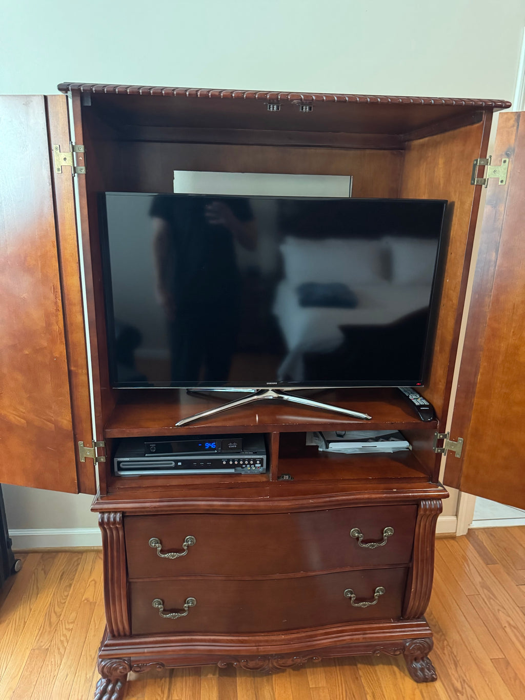 Interior of armoire showing television shelf and lower storage drawers with doors open